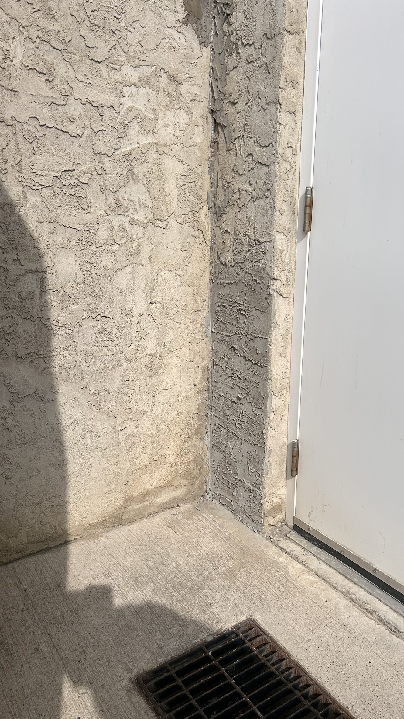Stucco repair detail beside a doorway on a Calgary exterior