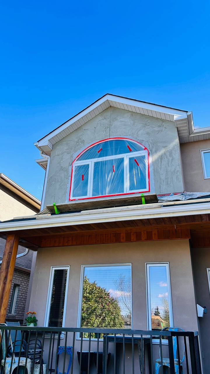 New arched window installed with flashing mesh visible — Calgary stucco home