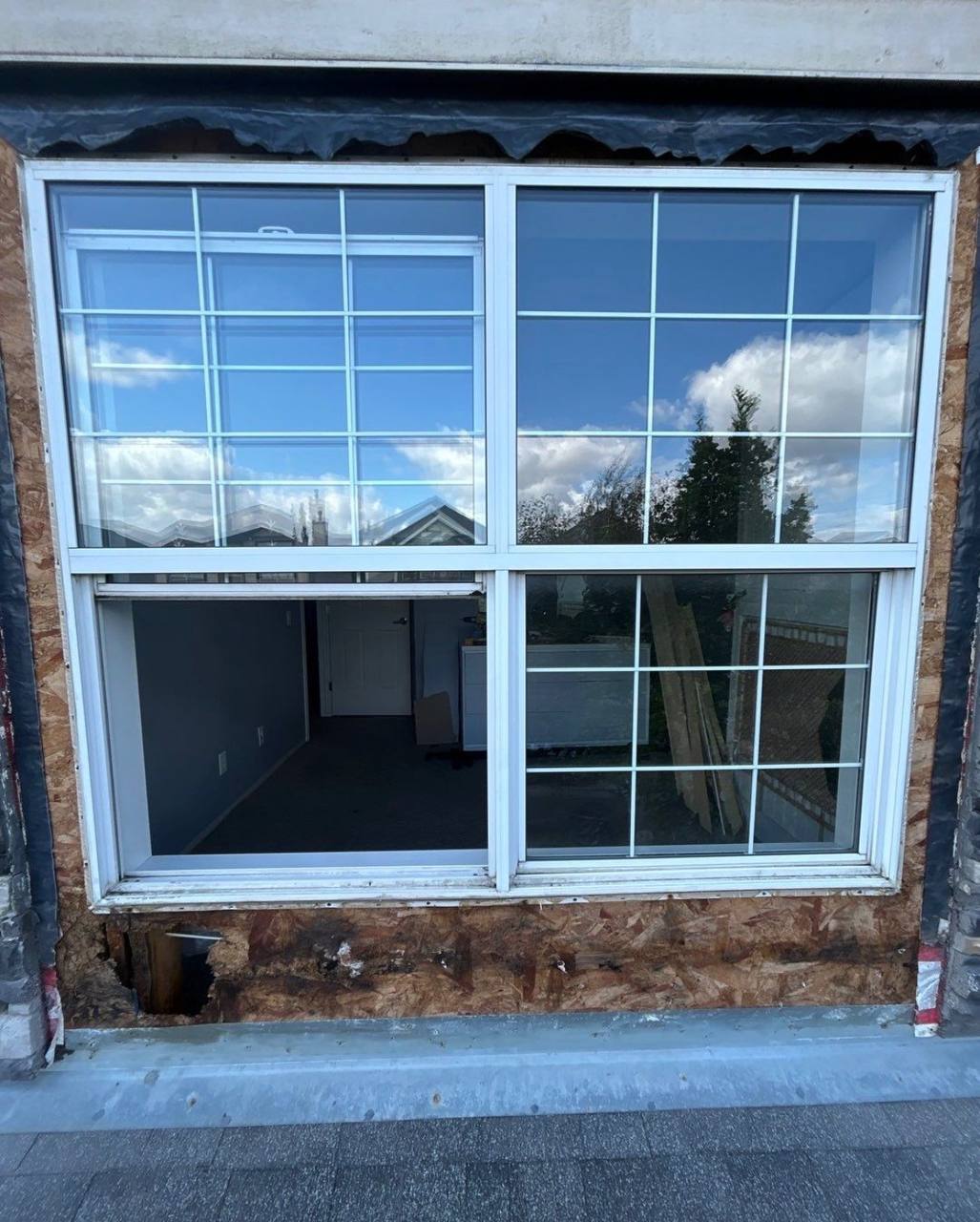 Existing window with an exposed wall area below it before replacement