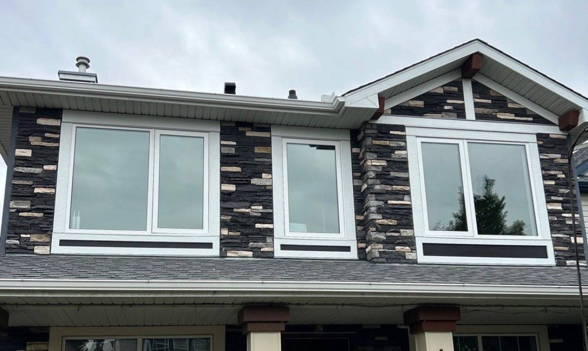 Finished exterior with white replacement windows and a new dark panel design