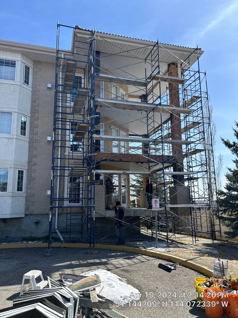 Exterior finishing project during work, with scaffold access alongside the building.