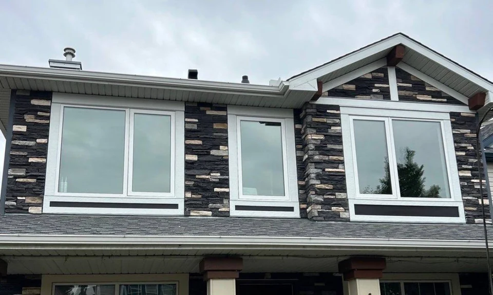 Finished exterior with white replacement windows and a new dark panel design