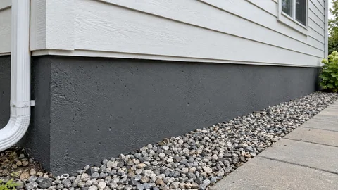 AI-generated service illustration of a charcoal gray protective coating on an exposed house foundation.